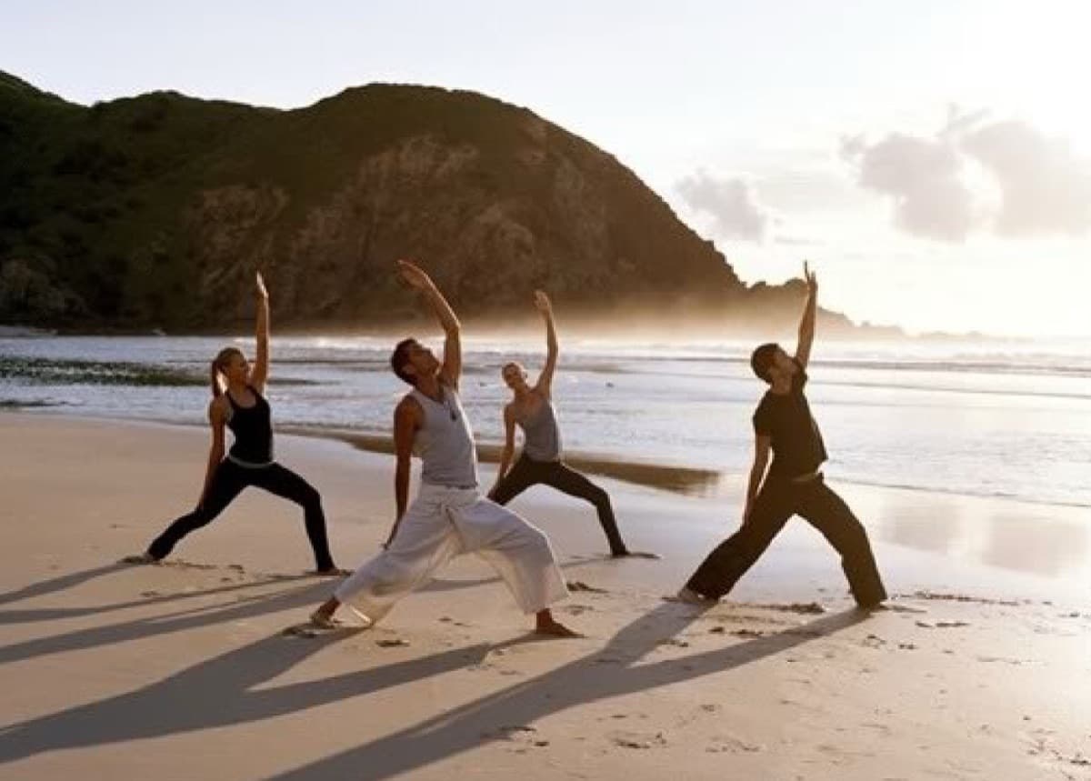 A small group practising yoga at golden hour